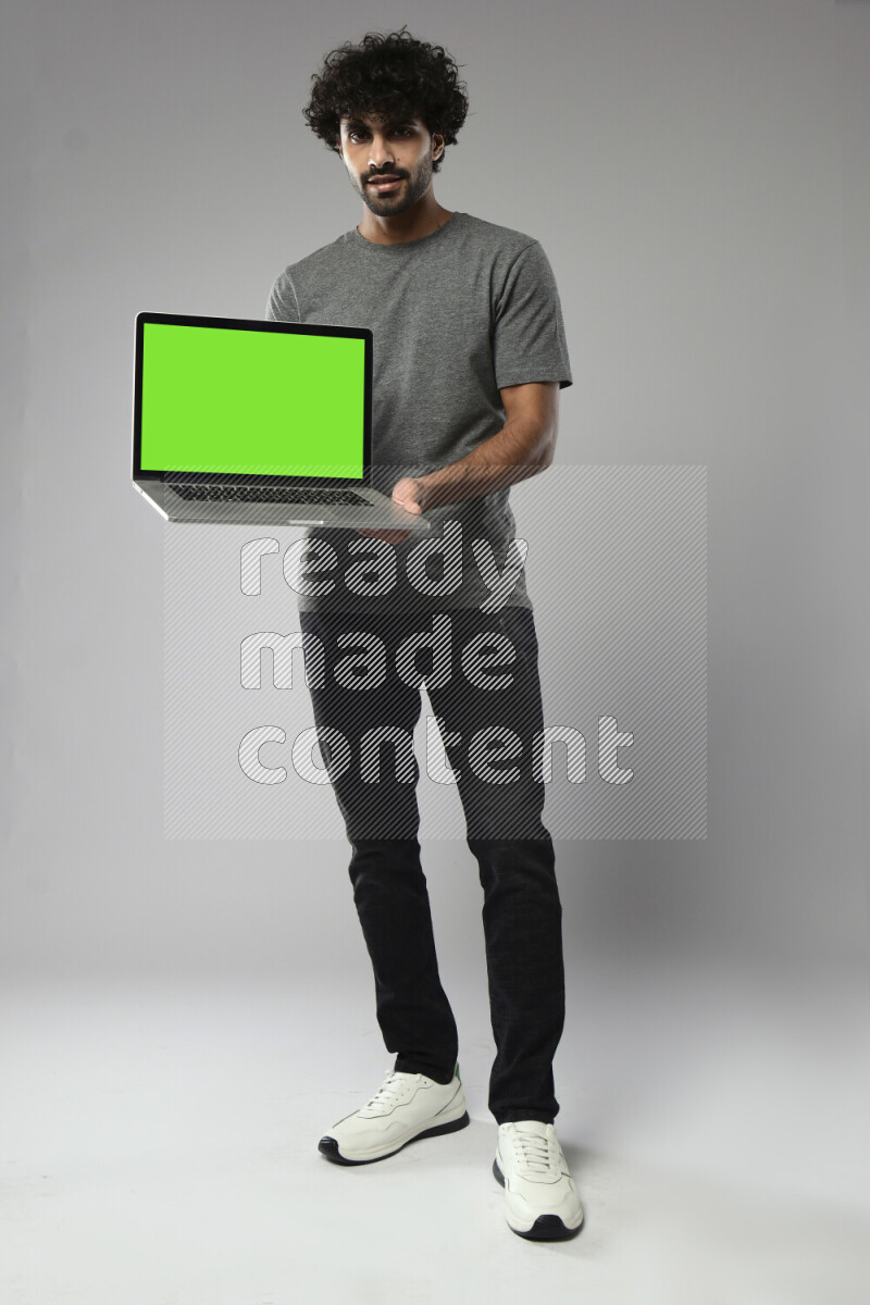 A man wearing casual standing and showing a laptop screen on white background