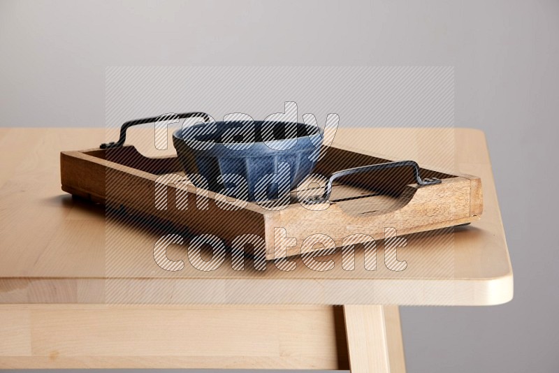 blue bowl on a light colored rectangular wooden tray with handles