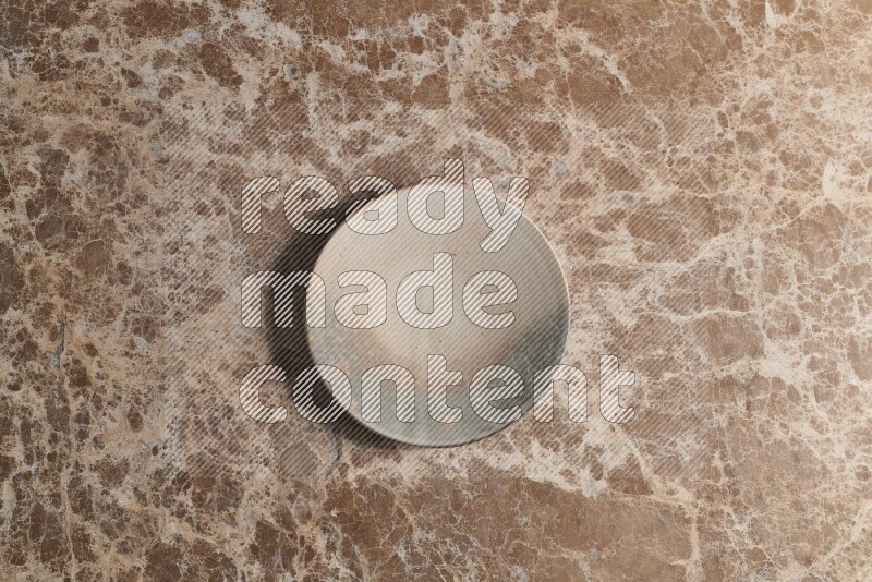 A multicolored pottery plate on beige marble background