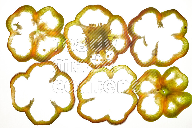 Colored bell pepper slices on illuminated white background