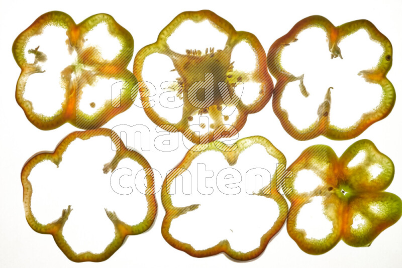 Colored bell pepper slices on illuminated white background