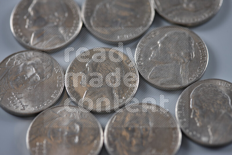 A close-up of scattered United States one dime coins on grey background