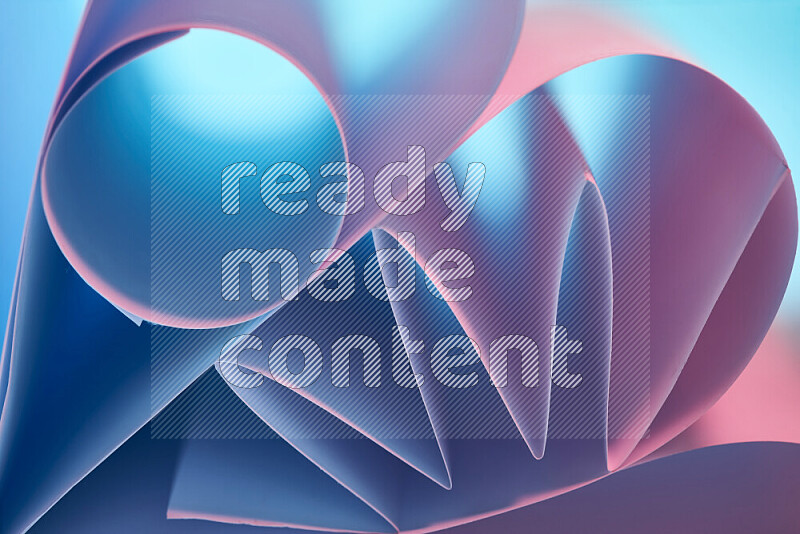 An artistic display of paper folds creating a harmonious blend of geometric shapes, highlighted by soft lighting in blue and pink tones