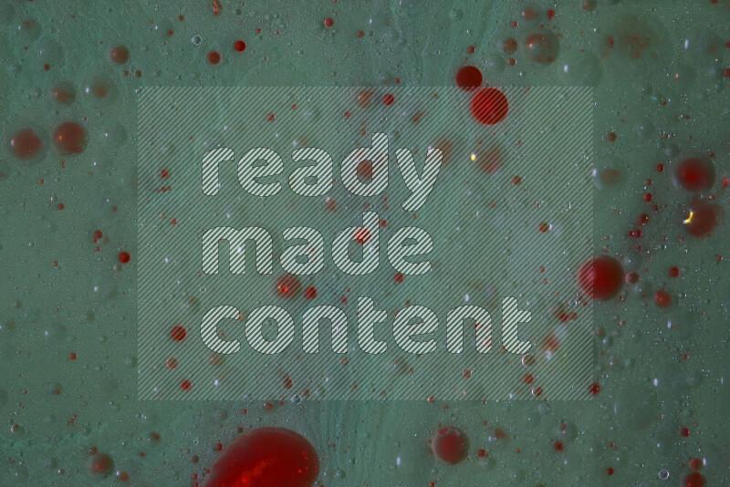 تلتقط الصورة تناثرا للطلاء الأحمر علي خلفية خضراء