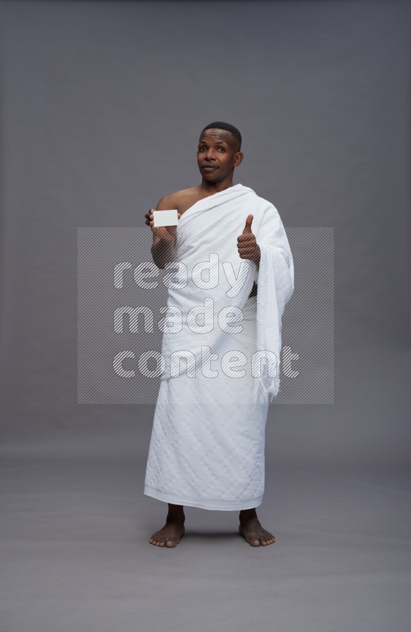 A man wearing Ehram Standing holding ATM card on gray background
