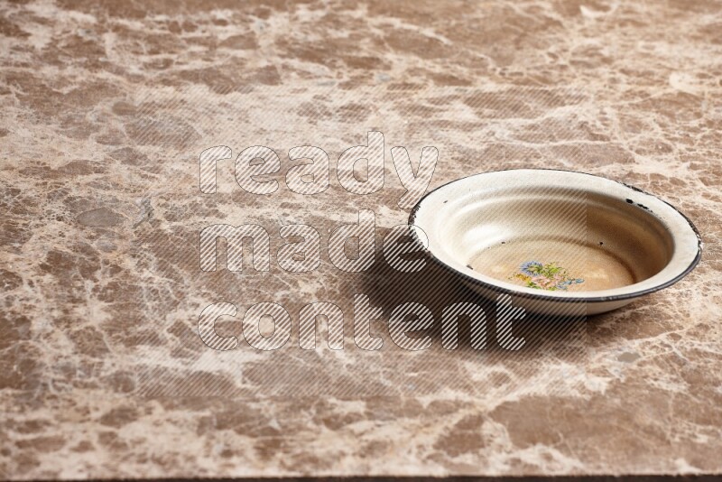 A vintage metal plate on beige marble background