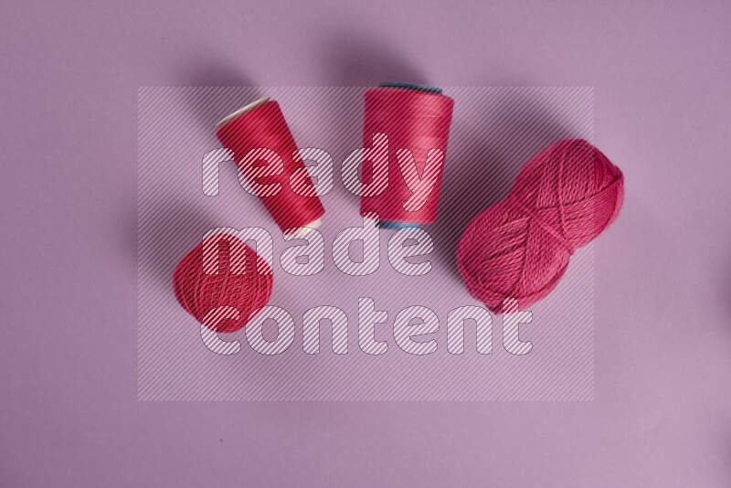 مجموعة من أدوات الخياطة والتفصيل زهرية وأرجوانية اللون على خلفية أرجوانية