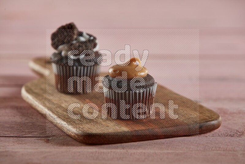 Chocolate mini cupcake topped with peanut butter on a wooden board