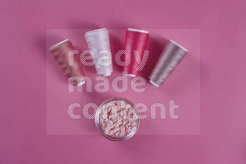 مجموعة من أدوات الخياطة والتفصيل زهرية اللون على خلفية زهرية