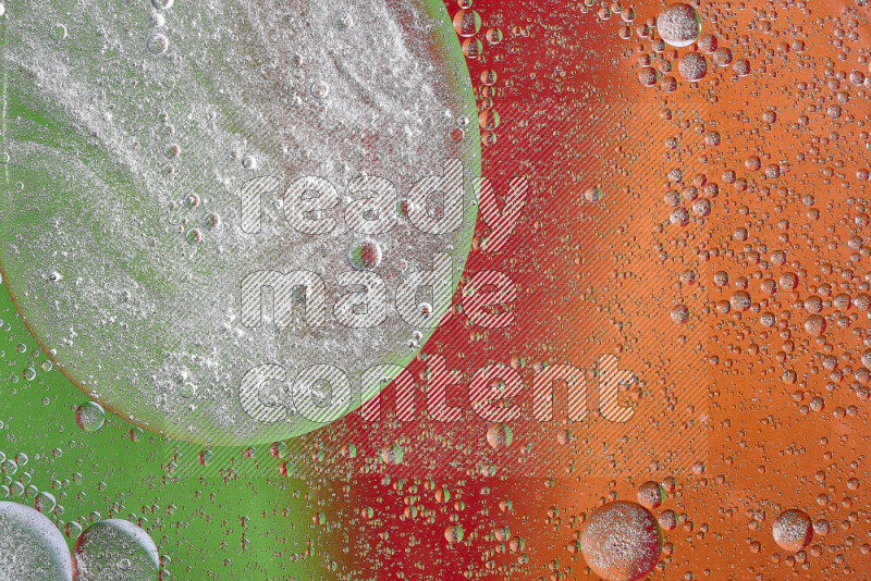 لقطات مقربة لفقاعات من الزيت على سطح الماء باللون البرتقالي والأخضر والأحمر