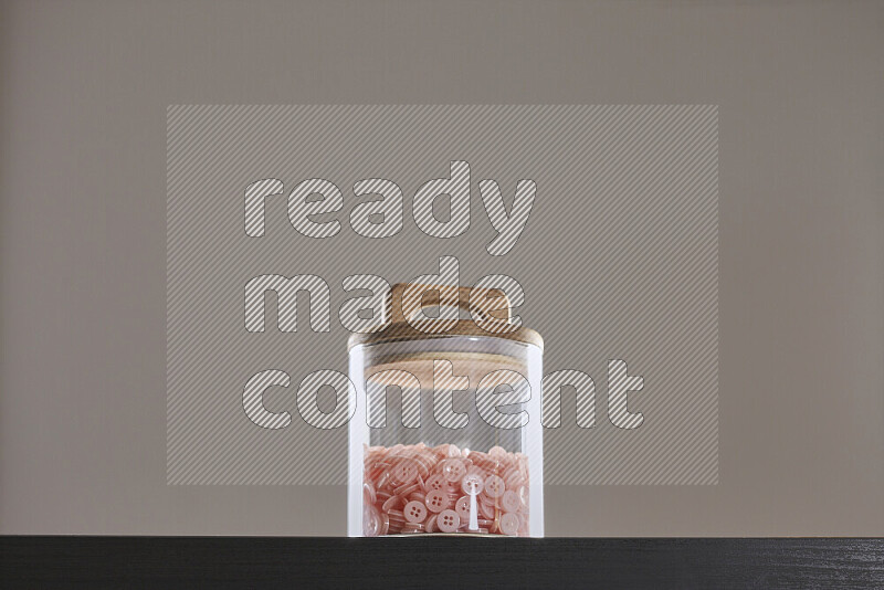 Buttons in a glass jar on black background