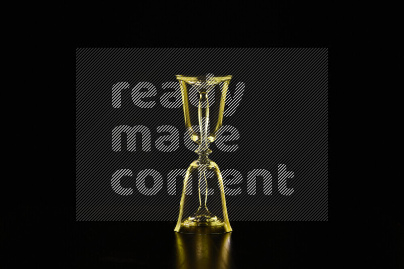 Glassware with rim light in yellow against black background