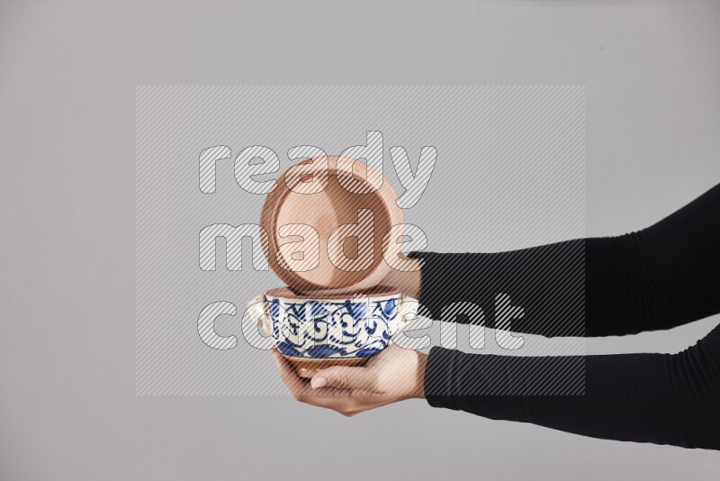 A woman in black abaya holding different pottery essentials in different positions