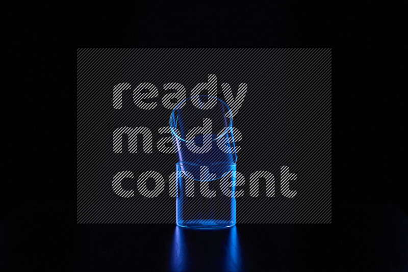 Glassware with rim light in blue against black background