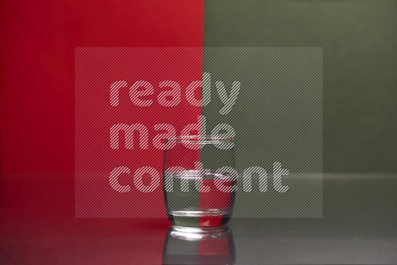 The image features a clear glassware filled with water, set against red and dark green background