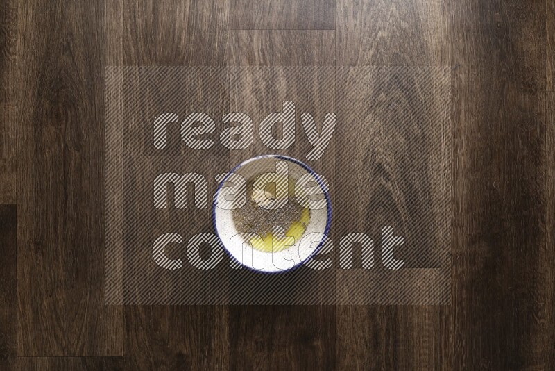 A bowl full of spices and salad dressing ingredients on wooden background