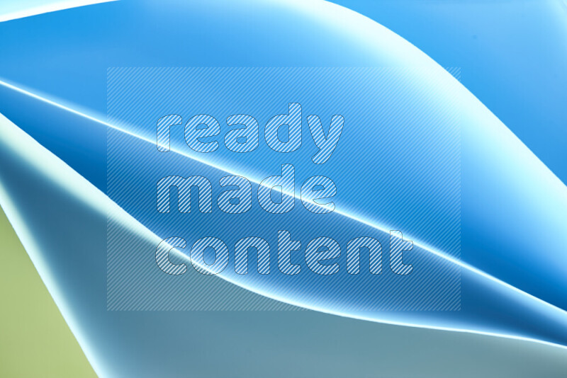 هذه الصورة تعرض تكوين فن الورق التجريدي مع منحنيات ورقية بتدرجات اللون الأخضر والأزرق المكونه بواسطة الضوء الملون