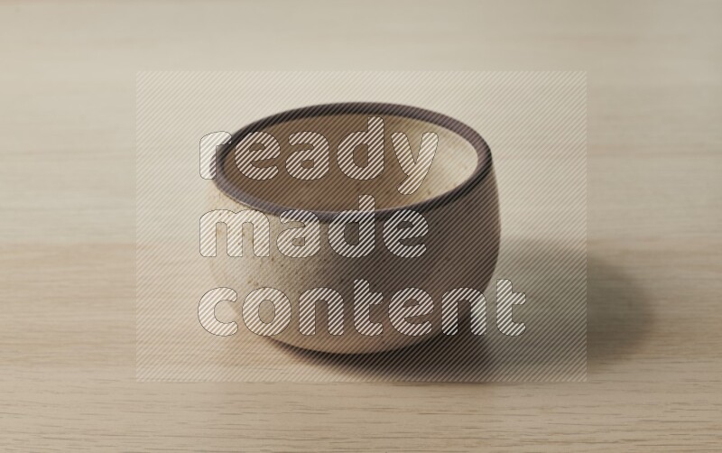 صحن فرن فخاري باللون البيج على خلفية خشبية فاتحة