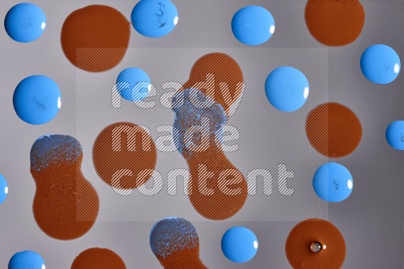 Close-ups of abstract orange and blue paint droplets on the surface