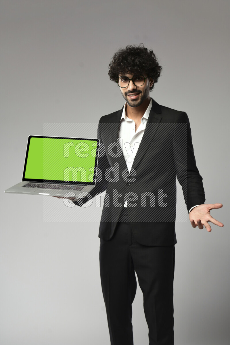 A man wearing formal standing and showing a laptop screen on white background