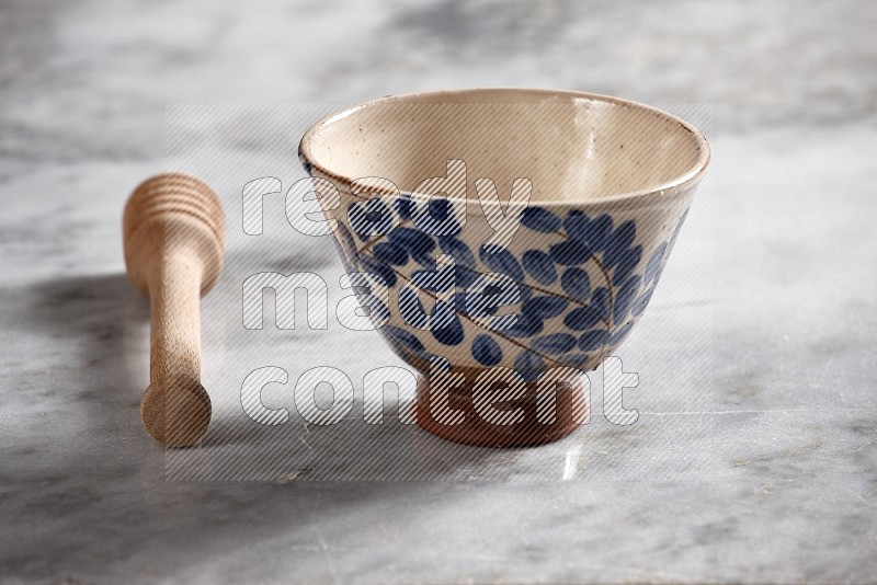 Decorative Pottery bowl with wooden honey handle on the side with grey marble flooring, 15 degree angle