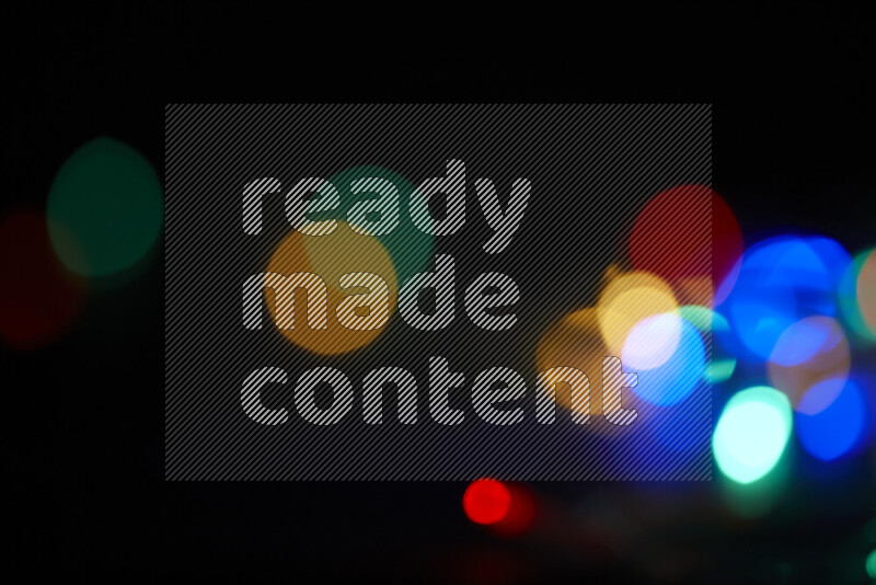 Light bulbs glowing against backdrop of multicolord bokeh