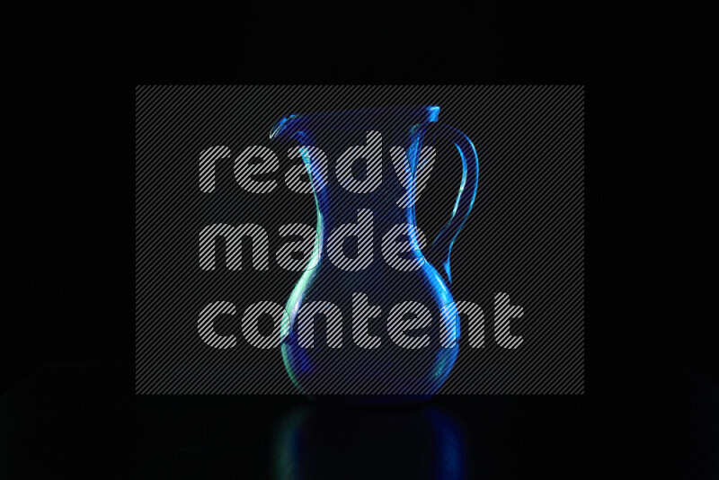 Glassware with rim light in blue and green against black background