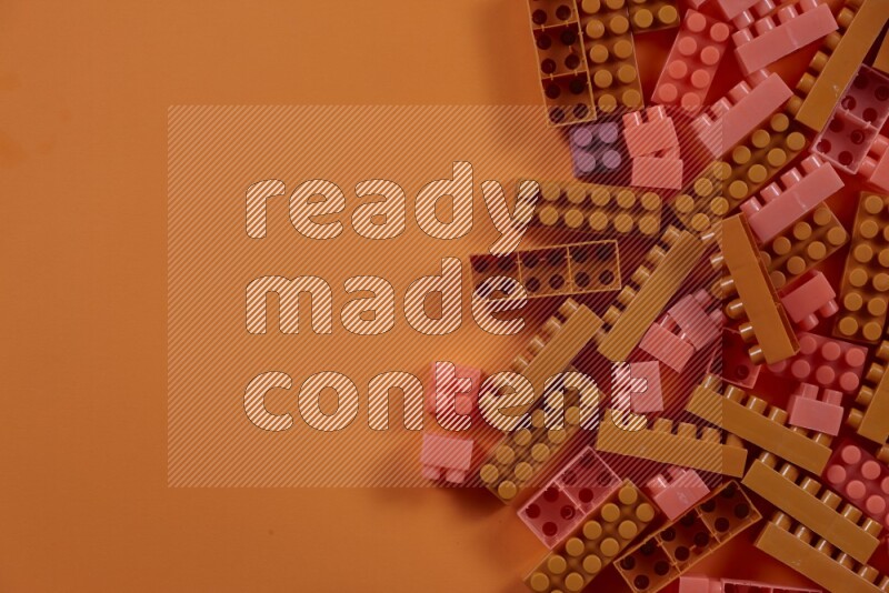 مكعبات بناء بلاستيكية برتقالية على خلفية برتقالية (ألعاب للأطفال)