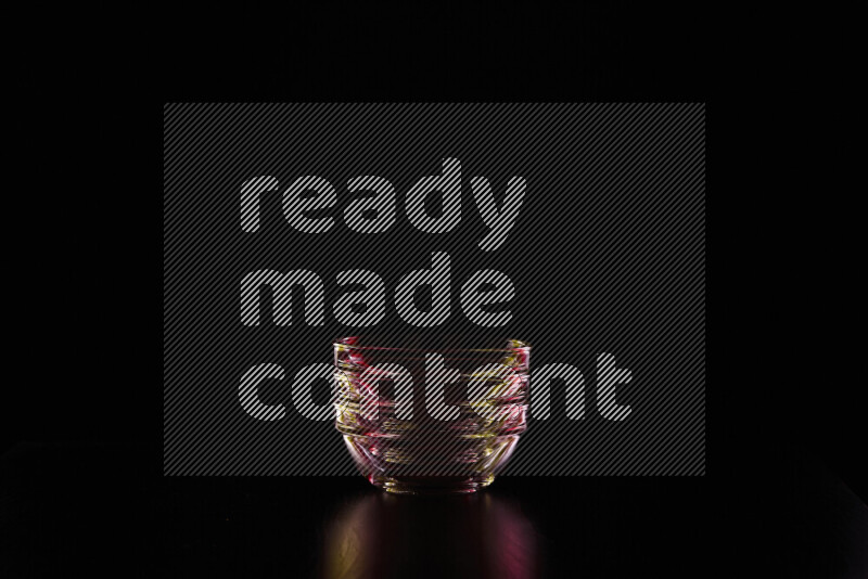 Glassware with rim light in red and yellow against black background