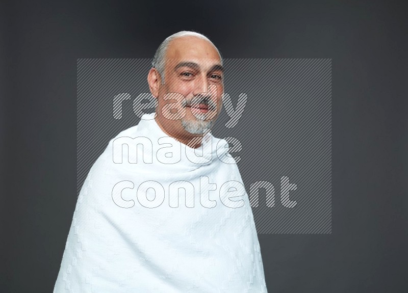 A man wearing Ehram Standing Interacting with the camera on gray background
