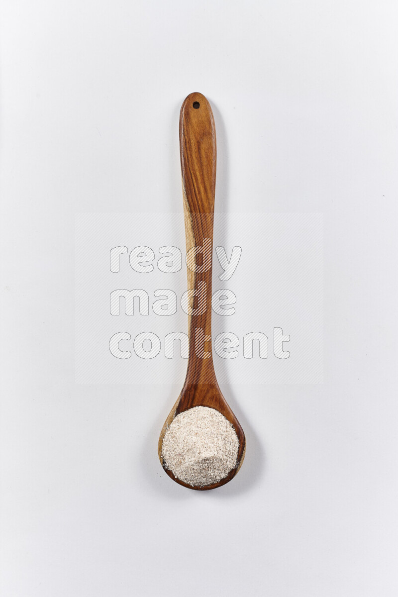 A wooden ladle full of onion powder on white background