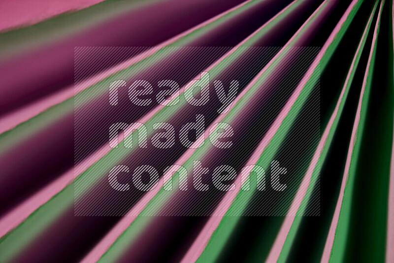 An image presenting an abstract paper pattern of lines in green and pink tones