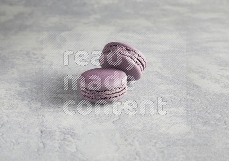 45º Shot of two Purple Blueberry macarons  on white  marble background