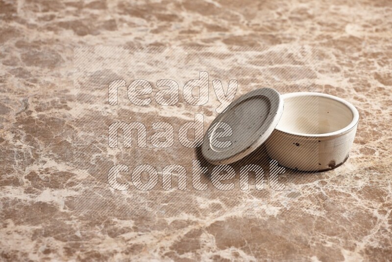 A white pottery bowl on beige marble background