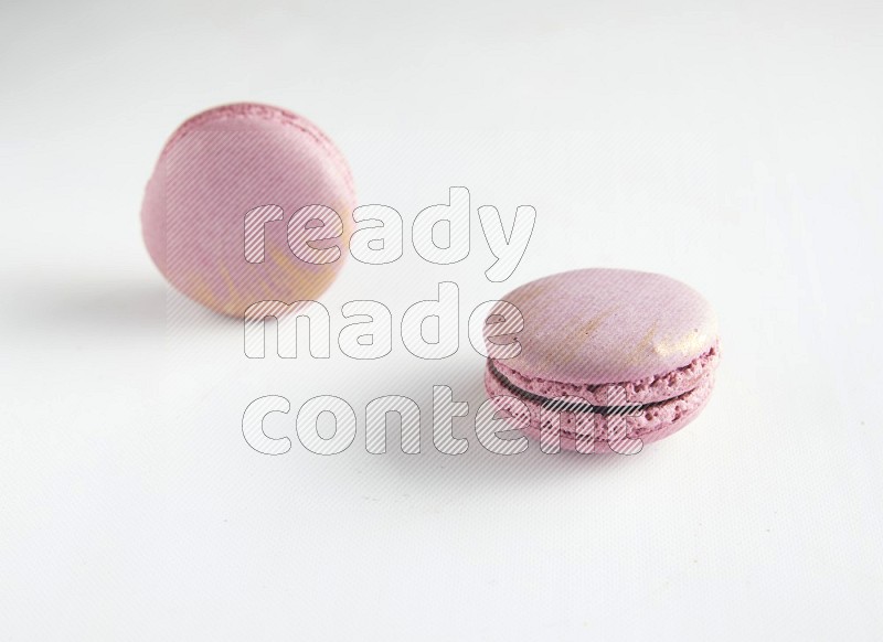 45º Shot of two Purple Strawberry macarons on white background
