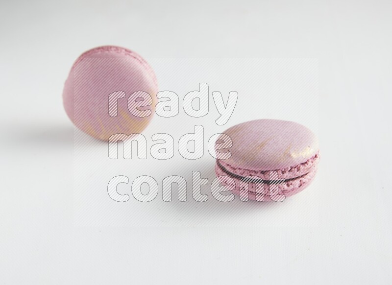 45º Shot of two Purple Strawberry macarons on white background