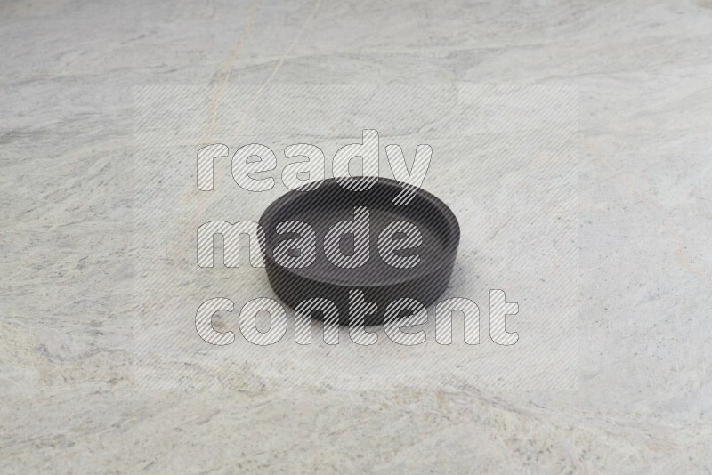A black pottery oven bowl on grey marble background