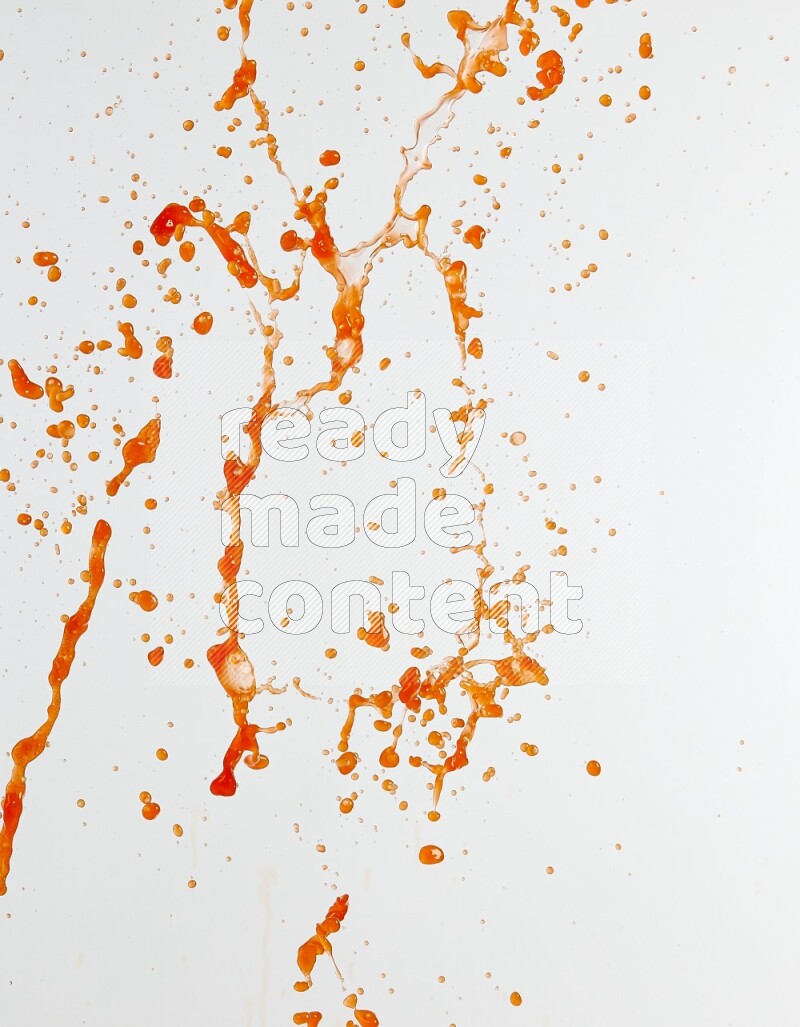 Orange liquid splash and drops on white background