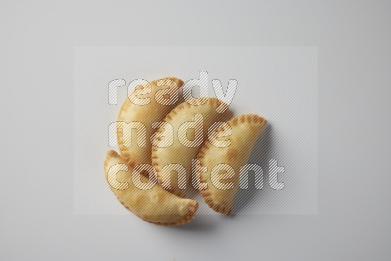 Four fried sambosa from a top angle on a white background