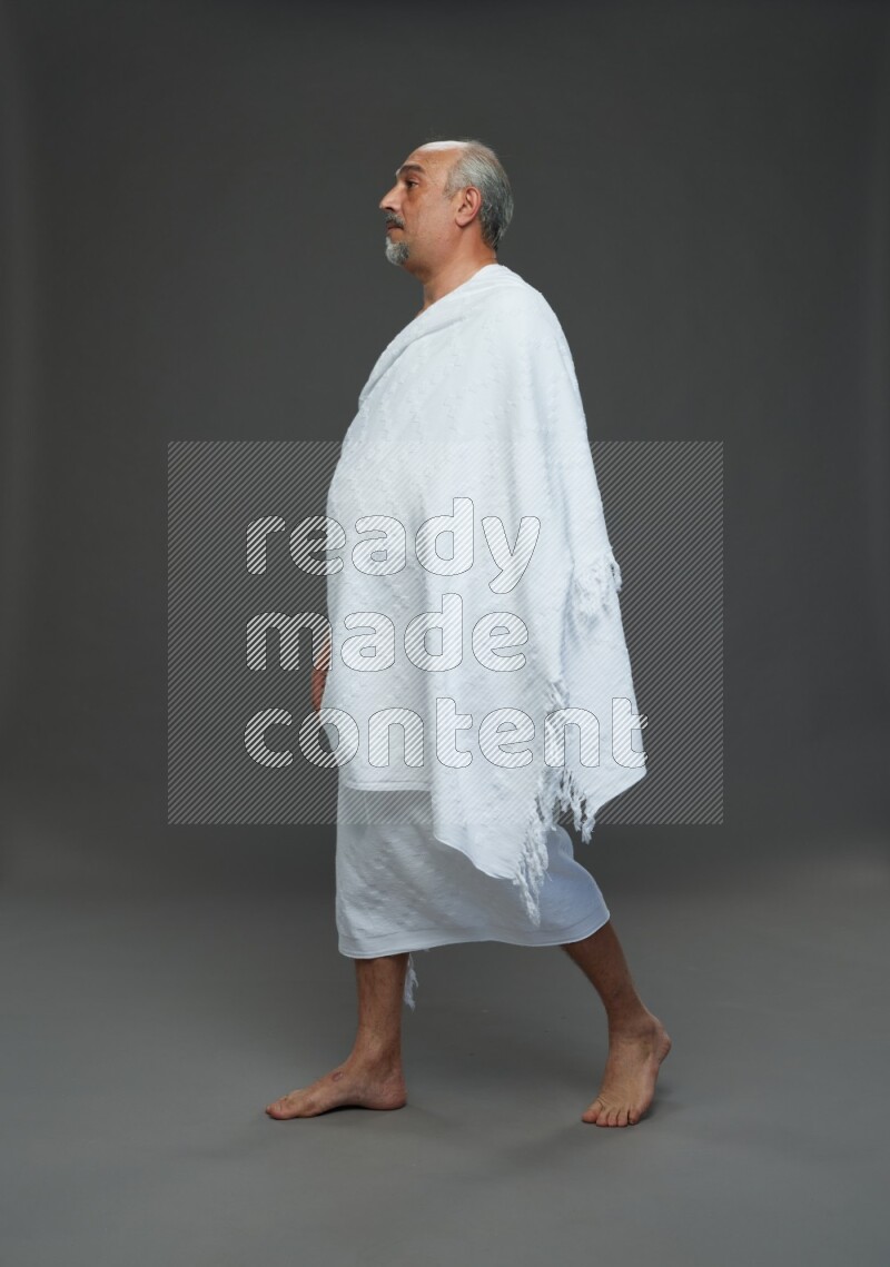 A man wearing Ehram Standing Interacting with the camera on gray background