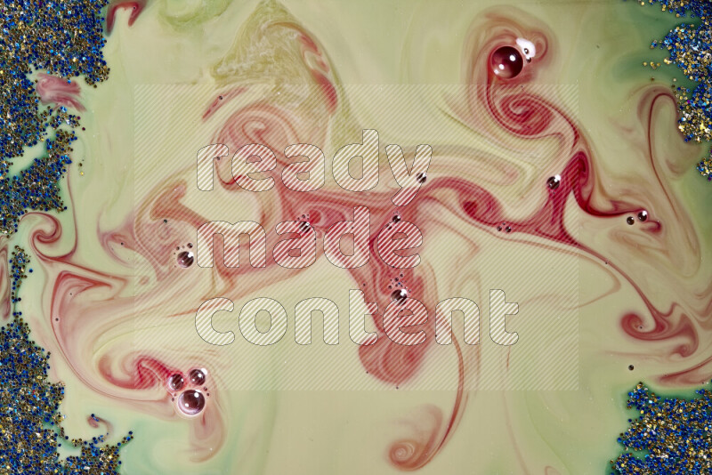 لقطة مقربة لبريق أزرق وذهبي متلألئ منتشر على خلفية من اللون الأخضر والأحمر في حركات دائرية