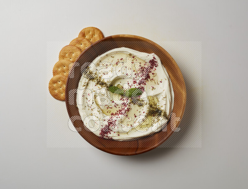 Lebnah garnished with  zattar , sumak & mint in a wooden plate on a white background