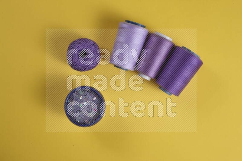 A purple collection of sewing and tailoring tools arranged on a yellow background