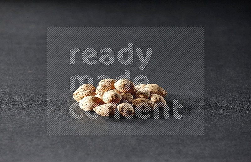 A bunch of almonds on a black background in different angles