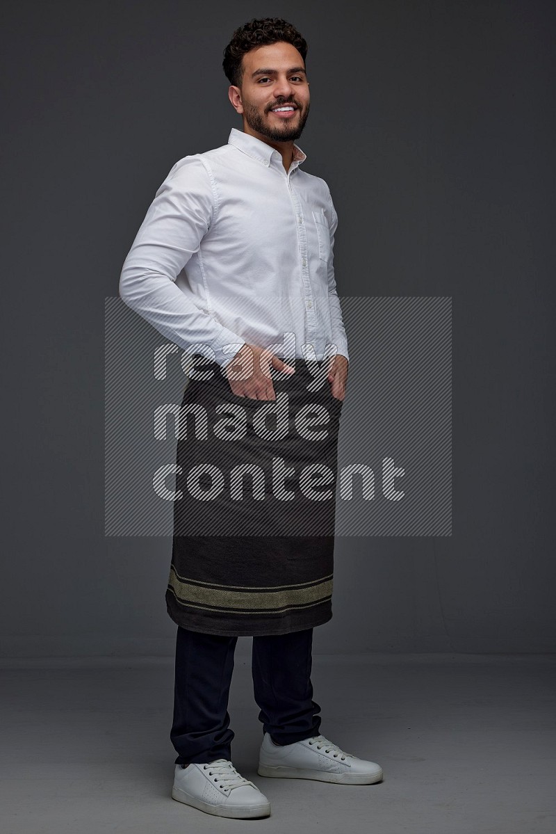 A man wearing smart casual and apron standing and making multi poses eye level on a gray background