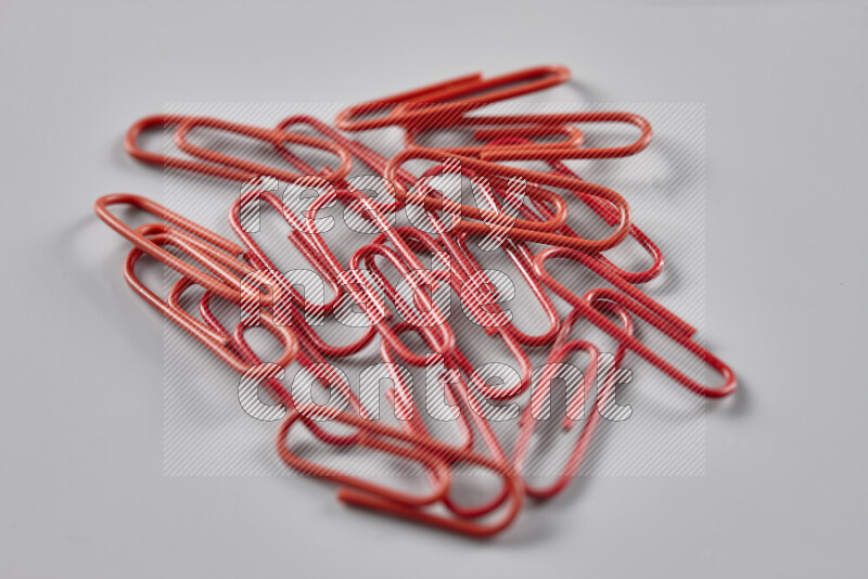Red paper clips isolated on a grey background