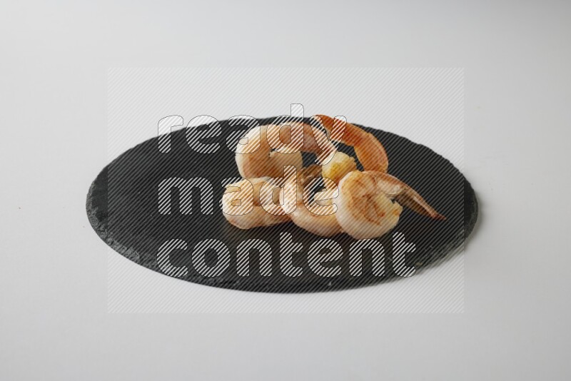 five grilled shrimps  on a black slate direct  on a white back ground