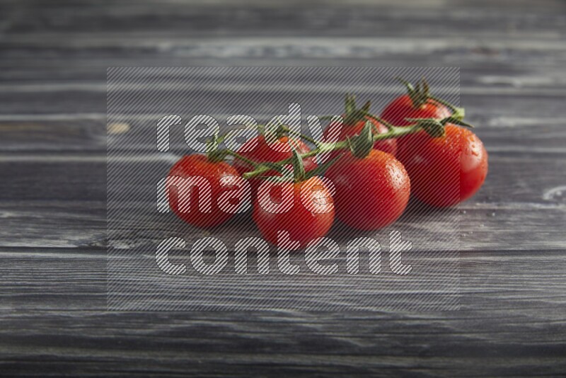 Red cherry tomato vein on a textured grey wooden background 45 degree