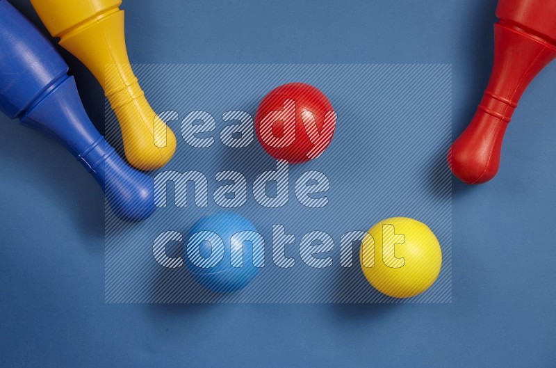 Plastic bowling pins with balls on different background in top view (kids toys)