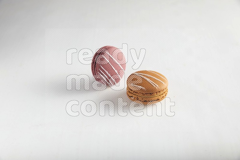 45º Shot of of two assorted Brown Irish Cream, and Red Poppy Flower macarons on white background